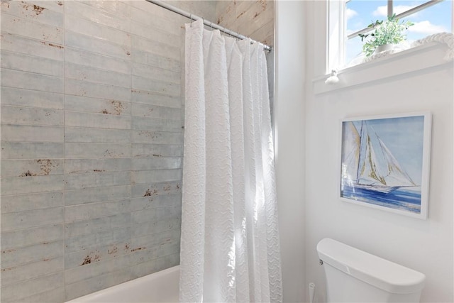 bathroom with shower / tub combo and toilet