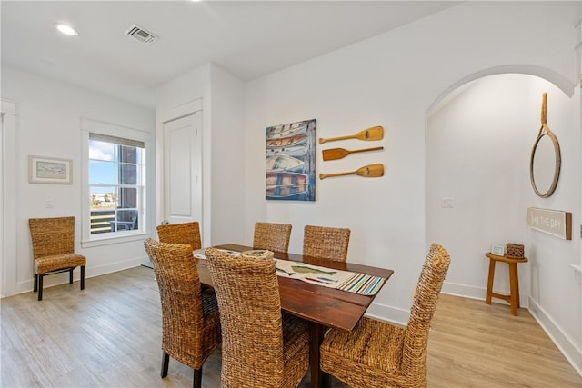 dining area with visible vents, recessed lighting, arched walkways, light wood-style floors, and baseboards