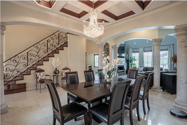 dining area with coffered ceiling, a chandelier, ornamental molding, and decorative columns