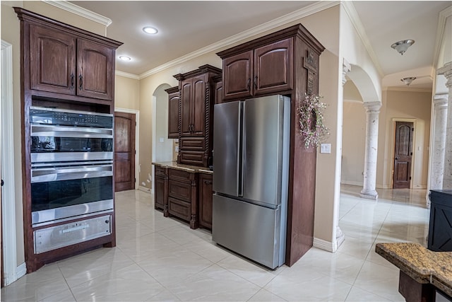 kitchen featuring stainless steel appliances, dark brown cabinetry, light stone counters, crown molding, and decorative columns