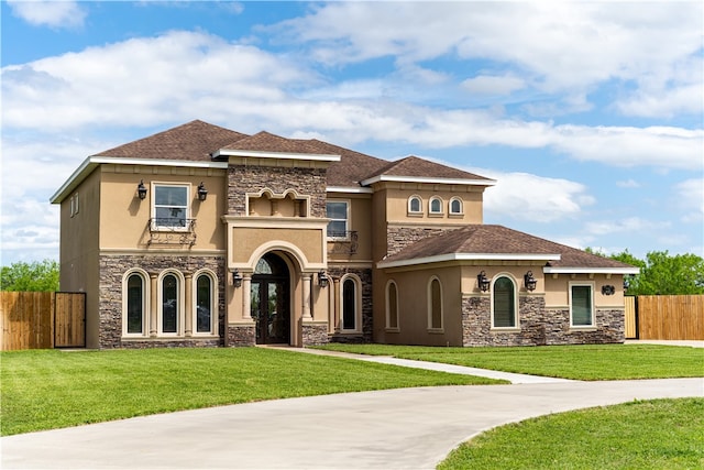 mediterranean / spanish house featuring a front lawn and a balcony