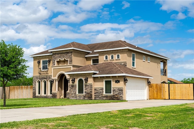 mediterranean / spanish home featuring a garage and a front yard