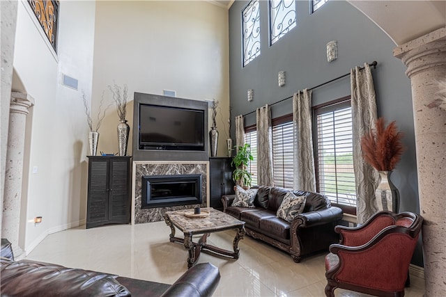 living room with a premium fireplace and decorative columns