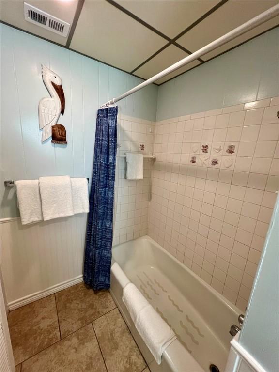 bathroom featuring shower / bath combo with shower curtain and tile patterned floors