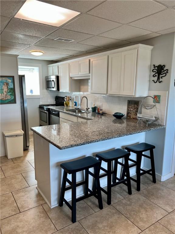 kitchen featuring white cabinetry, sink, kitchen peninsula, and stainless steel appliances