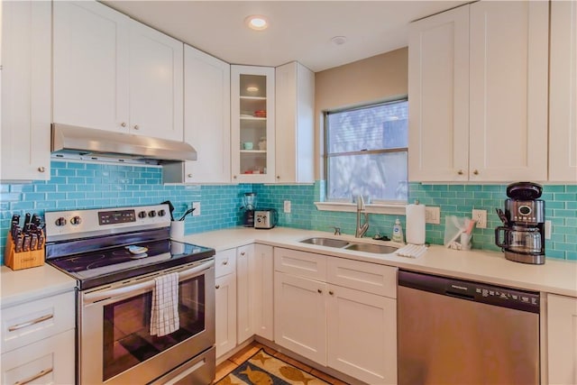 122 Palm Dr, Rockport, TX 78382 - kitchen featuring under cabinet range hood, appliances with stainless steel finishes, light countertops, and a sink