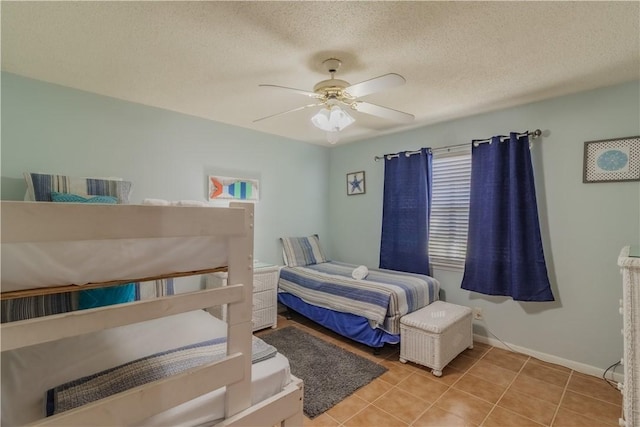 122 Palm Dr, Rockport, TX 78382 - bedroom featuring tile patterned floors, baseboards, a textured ceiling, and ceiling fan