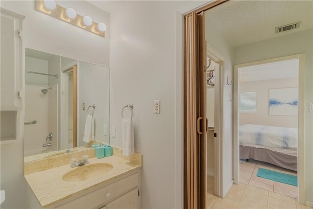 122 Palm Dr, Rockport, TX 78382 - bathroom with tile patterned flooring, visible vents, vanity, and ensuite bathroom