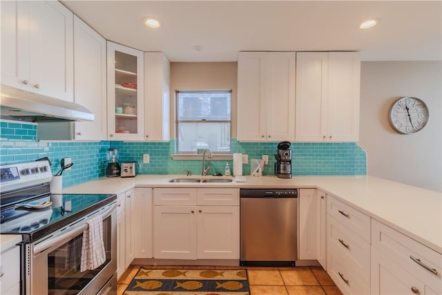 122 Palm Dr, Rockport, TX 78382 - kitchen featuring under cabinet range hood, light countertops, stainless steel appliances, white cabinetry, and a sink