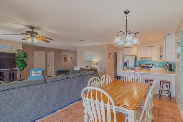 122 Palm Dr, Rockport, TX 78382 - dining area featuring light tile patterned flooring and ceiling fan with notable chandelier