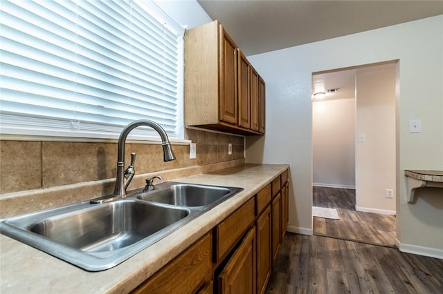 5921 Riley Dr, Corpus Christi, TX 78412 - kitchen featuring dark wood-style floors, decorative backsplash, brown cabinetry, and light countertops
