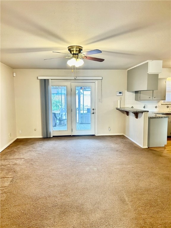 unfurnished living room with carpet floors and ceiling fan