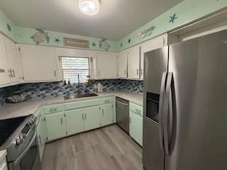 1638 W Palm Dr, Aransas Pass, TX 78336 - kitchen featuring appliances with stainless steel finishes, light countertops, decorative backsplash, and light wood finished floors