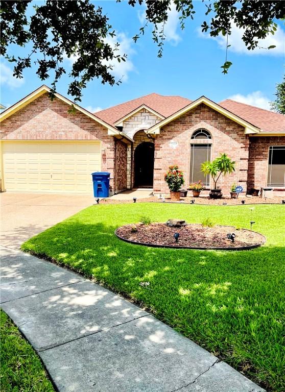 ranch-style home with a front yard and a garage