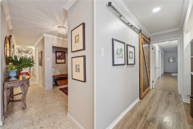 corridor with light hardwood / wood-style flooring, a barn door, and crown molding