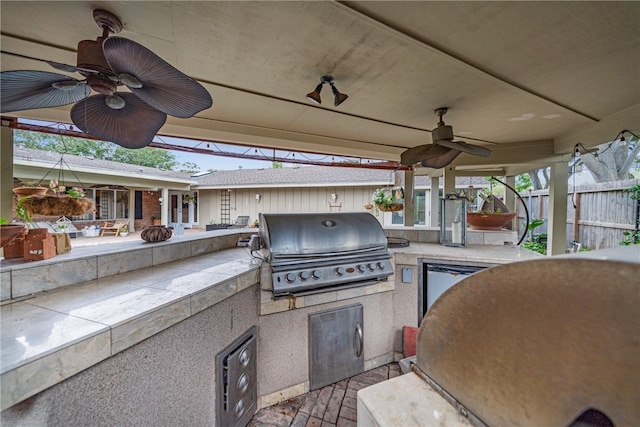 view of patio / terrace with ceiling fan, a grill, and exterior kitchen