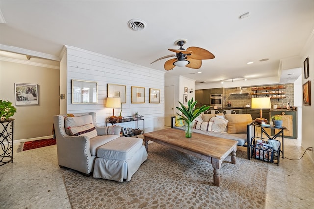 living room with ceiling fan and ornamental molding