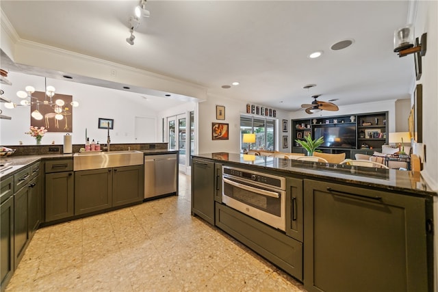 kitchen featuring crown molding, appliances with stainless steel finishes, hanging light fixtures, sink, and dark stone countertops