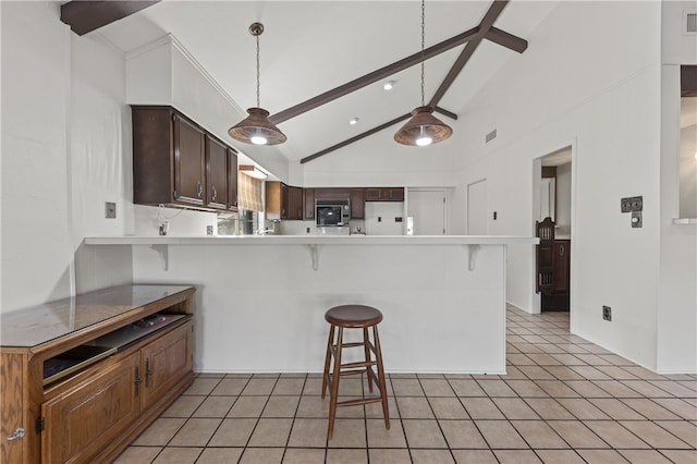 kitchen featuring lofted ceiling with beams, white fridge, light tile patterned flooring, a kitchen breakfast bar, and kitchen peninsula