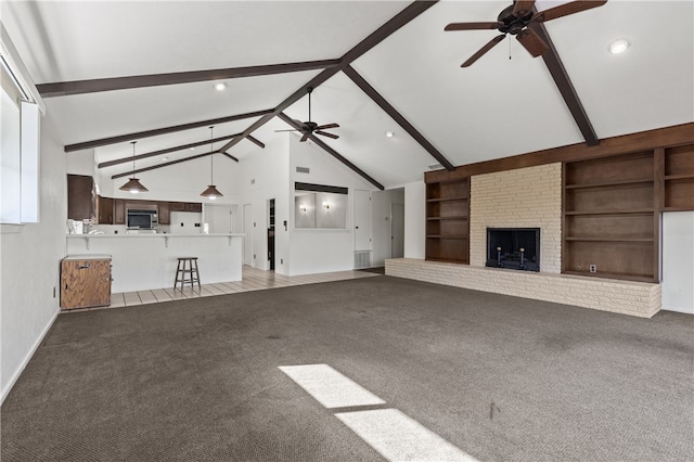 unfurnished living room featuring carpet flooring, a brick fireplace, built in features, and beamed ceiling