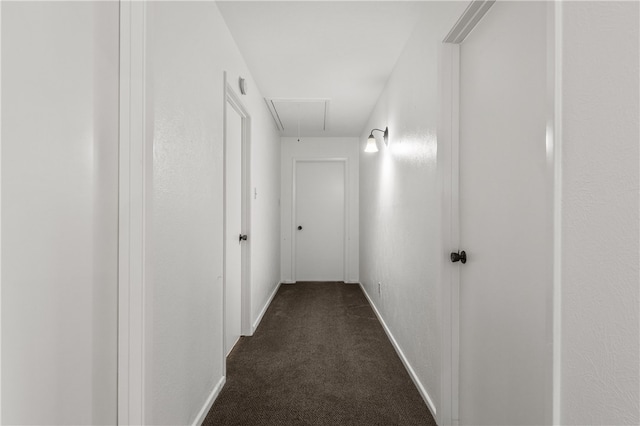 hallway with dark colored carpet