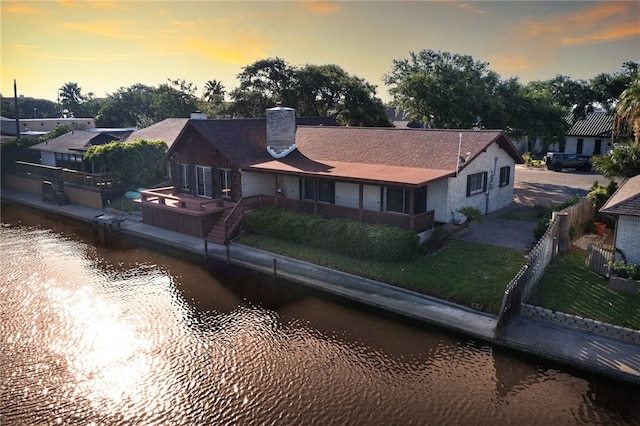 view of front facade with a water view and a lawn