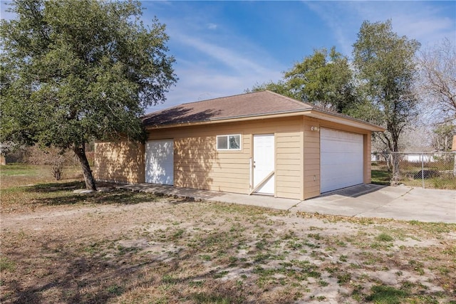 detached garage featuring fence