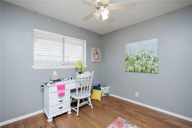 home office featuring a ceiling fan, baseboards, and wood finished floors