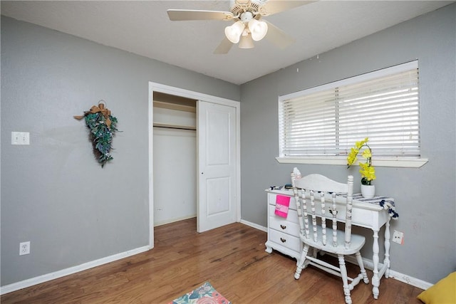 home office featuring a ceiling fan, baseboards, and wood finished floors