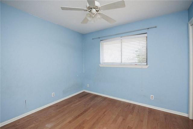 spare room featuring a ceiling fan, baseboards, and wood finished floors