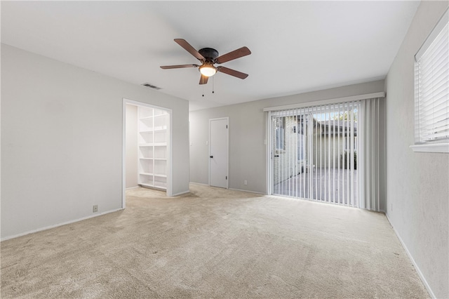 carpeted empty room featuring ceiling fan