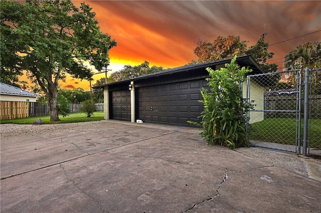 garage at dusk featuring a yard