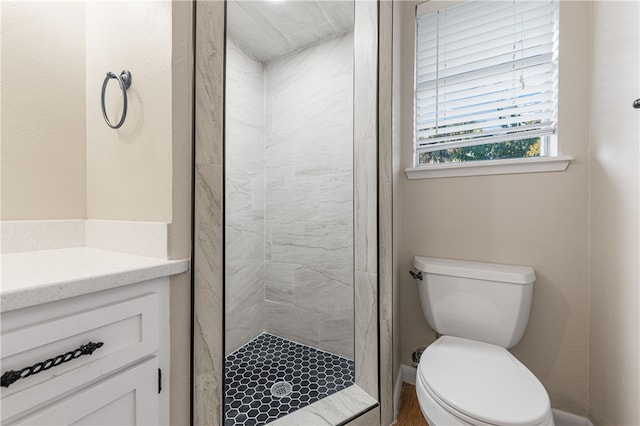 bathroom featuring toilet and a tile shower