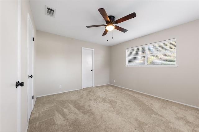 spare room featuring ceiling fan and light carpet