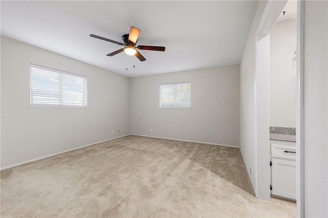 carpeted spare room with ceiling fan