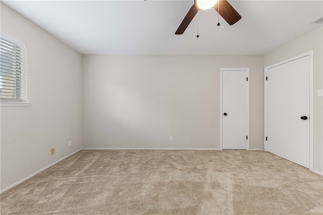 carpeted spare room with ceiling fan