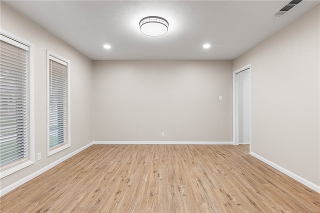 unfurnished room with a textured ceiling and light hardwood / wood-style flooring