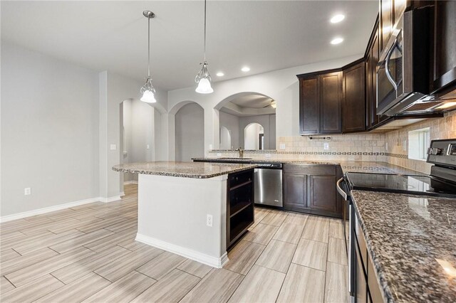 1012 Santa Catalina St, Portland, TX 78374 - kitchen featuring appliances with stainless steel finishes, arched walkways, dark brown cabinets, decorative backsplash, and recessed lighting
