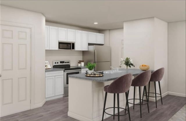 kitchen featuring white cabinets, hardwood / wood-style flooring, stainless steel range with electric stovetop, and fridge