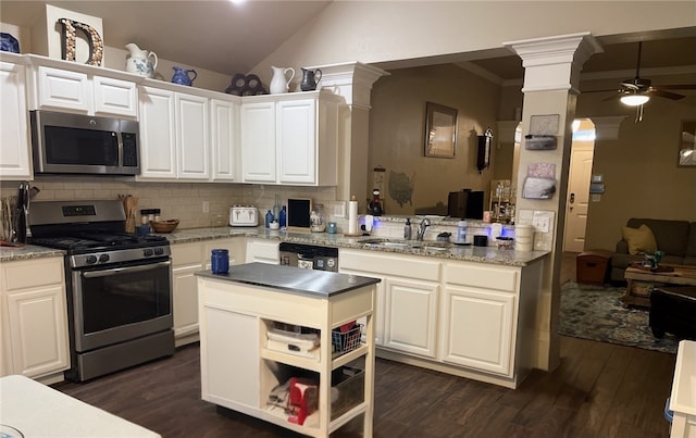 kitchen featuring appliances with stainless steel finishes, white cabinetry, ceiling fan, backsplash, and decorative columns