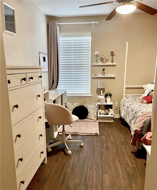 bedroom featuring multiple windows, dark hardwood / wood-style floors, and ceiling fan