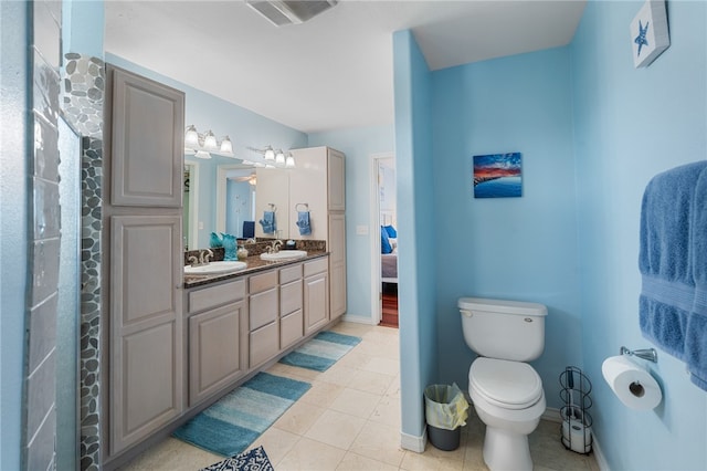 bathroom with toilet, vanity, and tile patterned floors