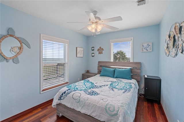 bedroom with multiple windows, ceiling fan, and dark hardwood / wood-style floors