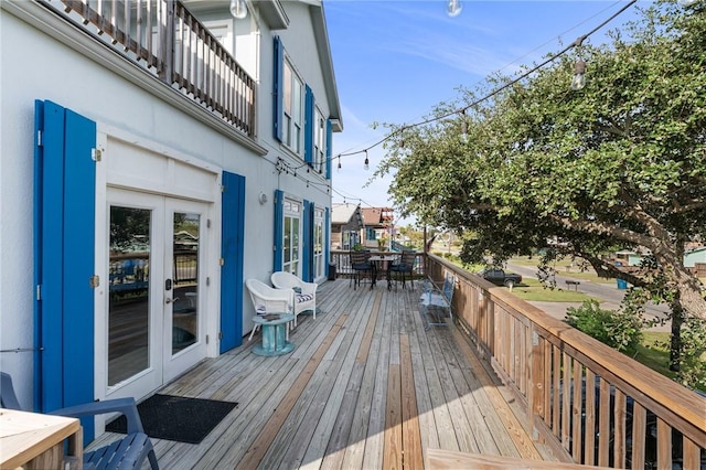 deck featuring outdoor dining area and french doors