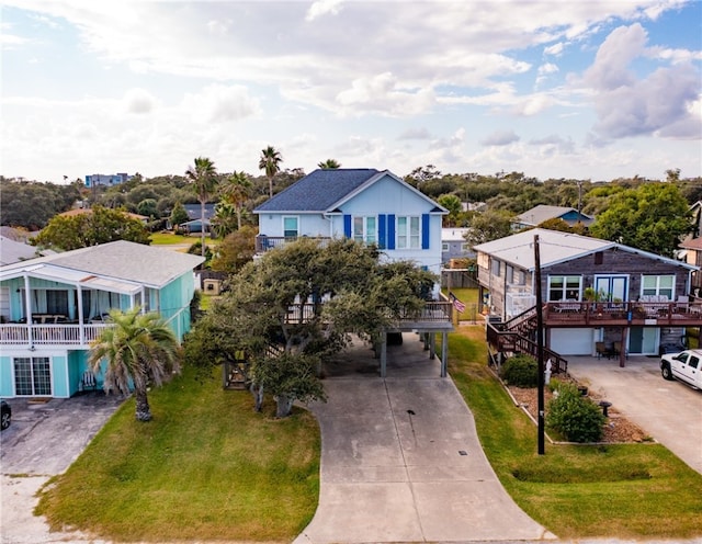 coastal home with a garage, a front yard, and a balcony