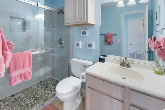 bathroom with walk in shower, vanity, and toilet