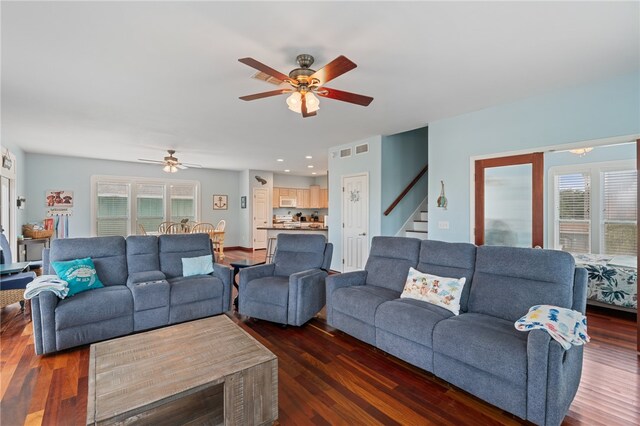 living room with dark hardwood / wood-style flooring and ceiling fan