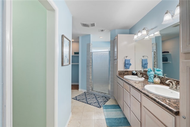 bathroom featuring a shower with door, vanity, and tile patterned floors