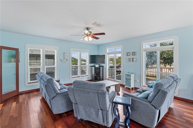 living room featuring dark wood-type flooring and ceiling fan