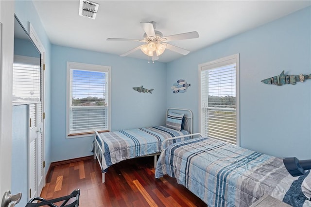 bedroom featuring multiple windows, wood finished floors, ceiling fan, and baseboards